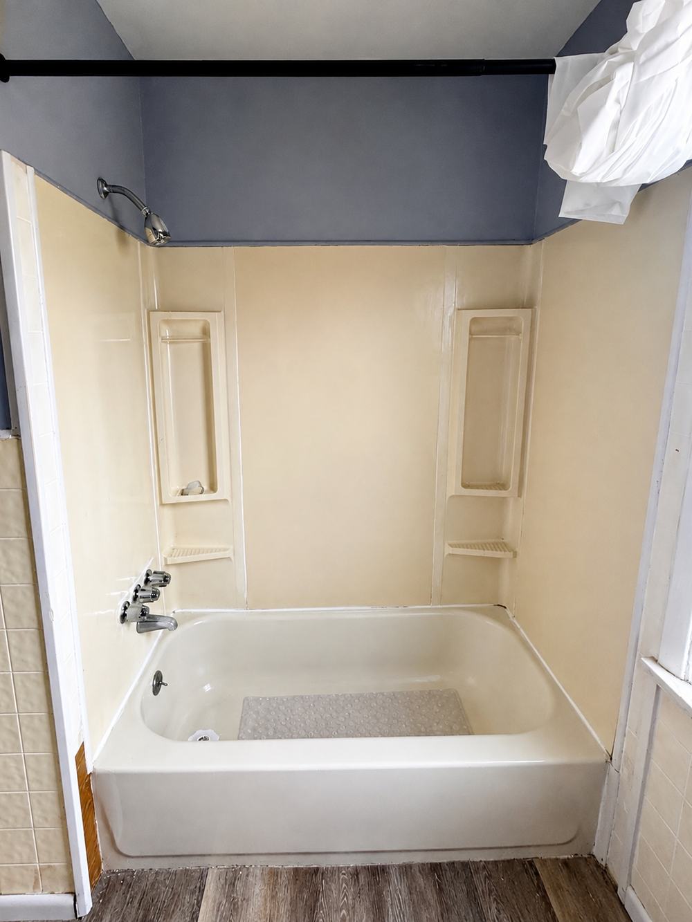 Tub surround before - dated yellowed shower walls